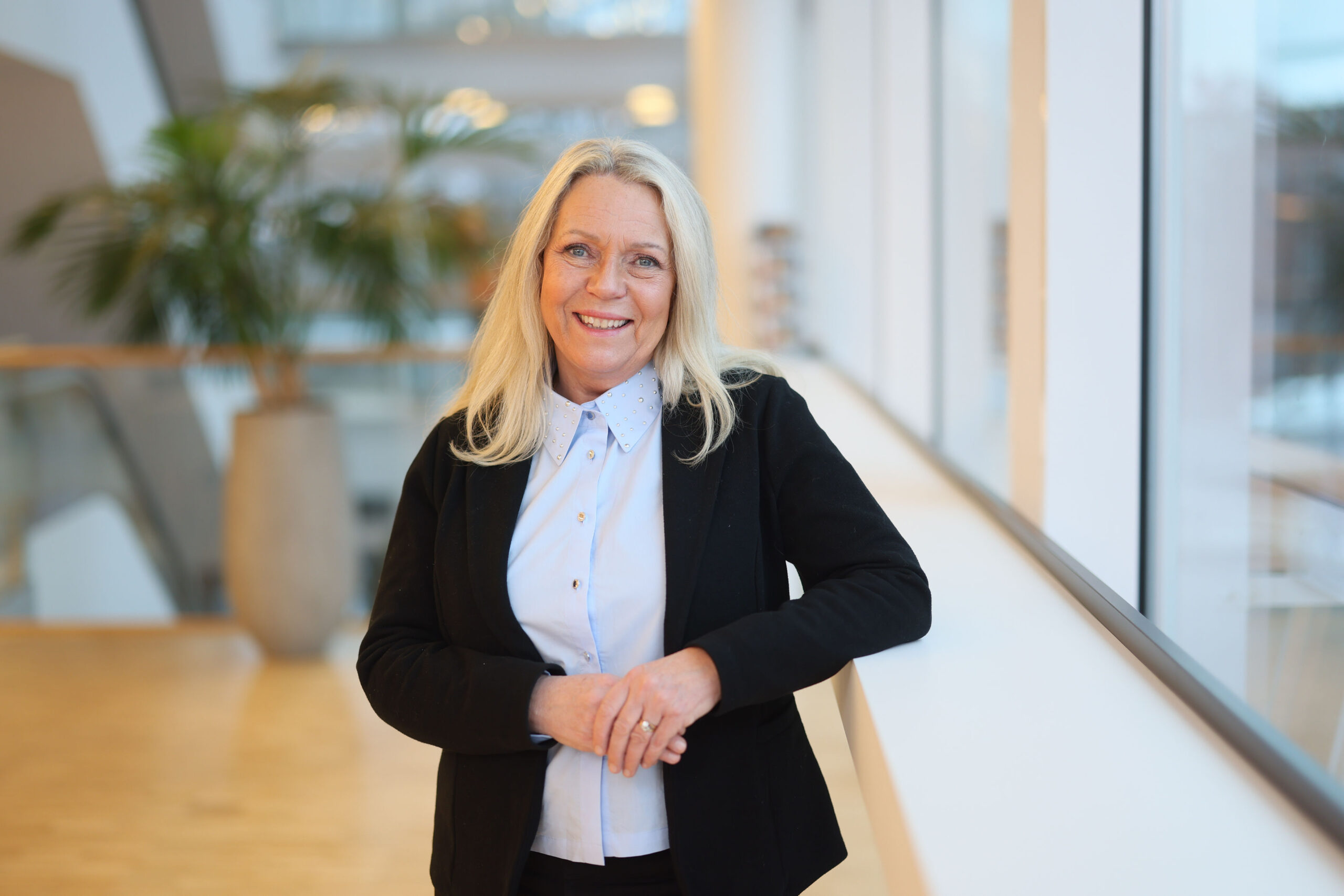 Porträtt kvinna med ljust hår och svart kavaj