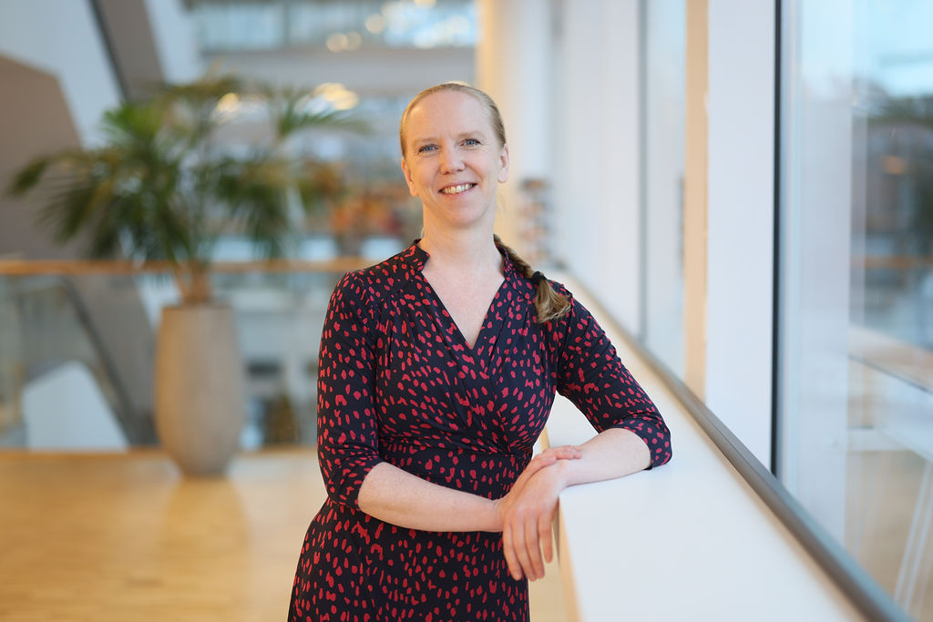 Porträtt kvinna med håret i en fläta och rödprickig klänning