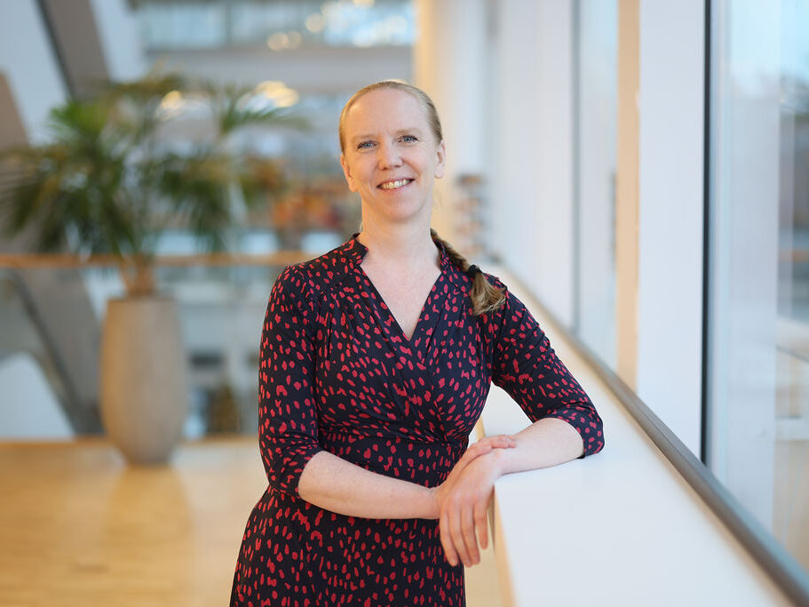 Porträtt kvinna med håret i en fläta och rödprickig klänning